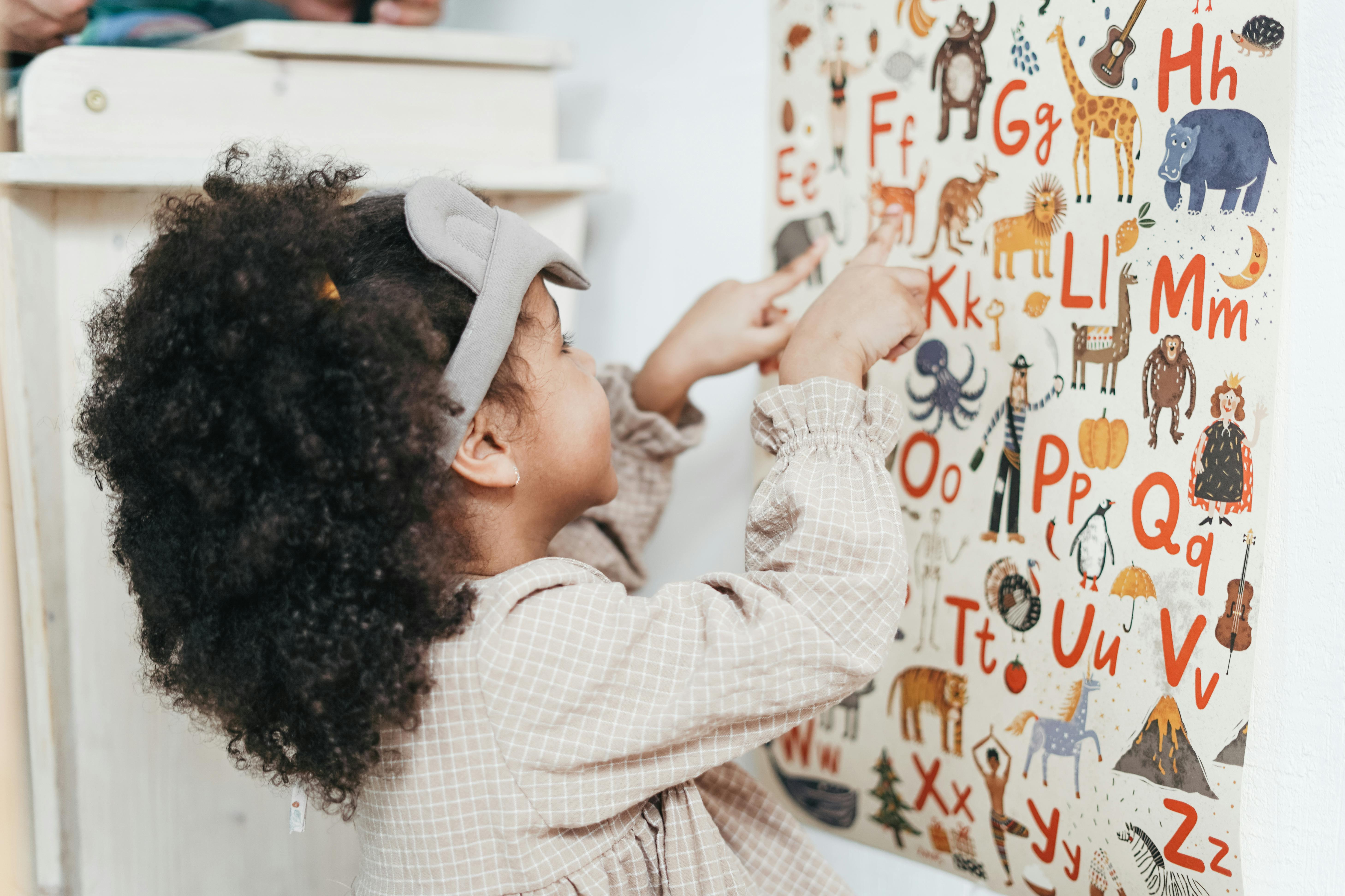 Petite fille jouant avec un tableau représentant l'alphabet